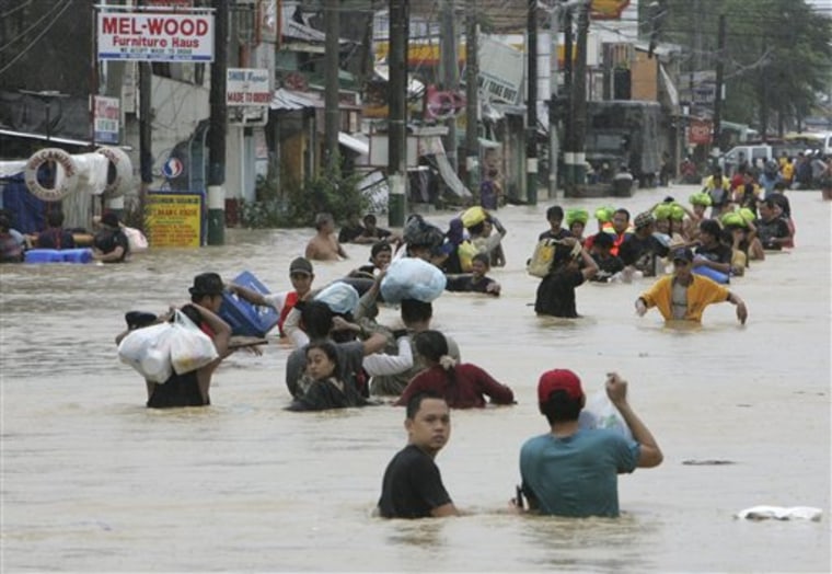 Residents evacuate to safer grounds as massive flooding continues for the second day Saturday at Calumpit township, Bulacan province north of Manila, Philippines.